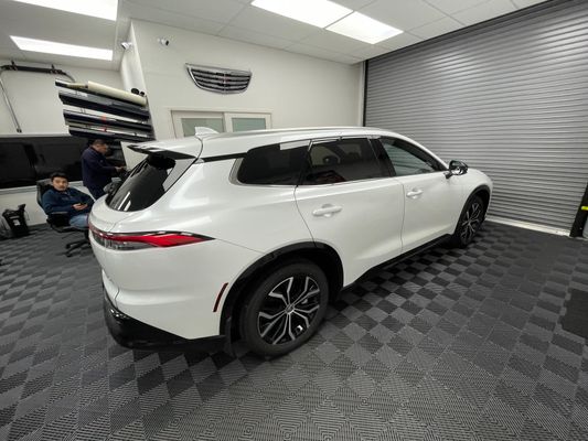 White SUV with tinted rear windows in the PWT shop bay
