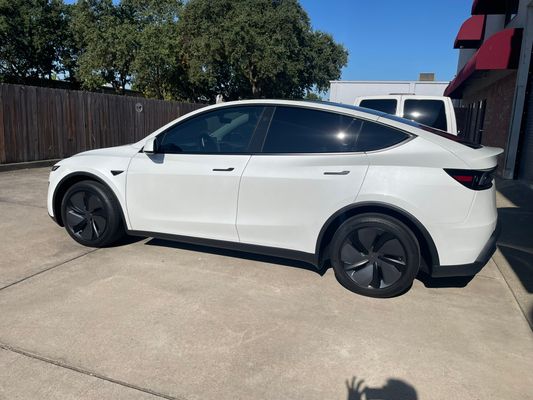 White Tesla Model Y with completed window tint outside the shop