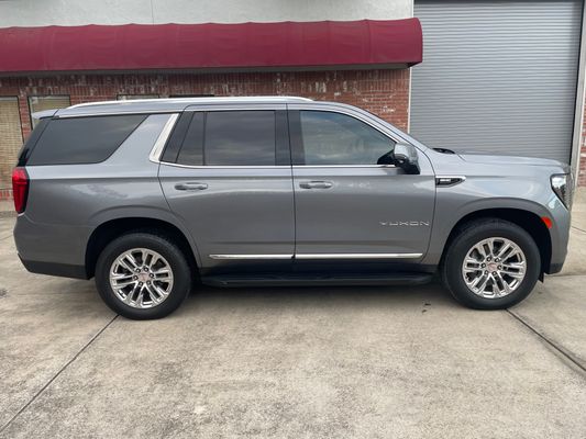 Gray GMC Yukon with full window tint package