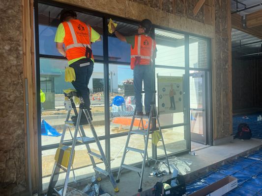 Pacific Window Tint crew installing commercial storefront film on ladders