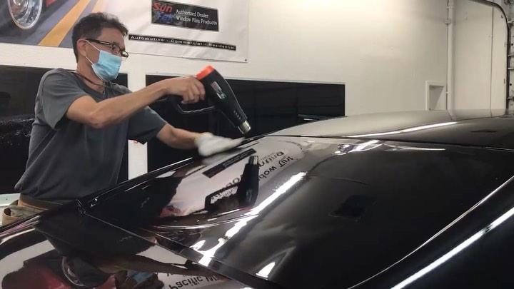 Installer heat fitting film on a black rear window