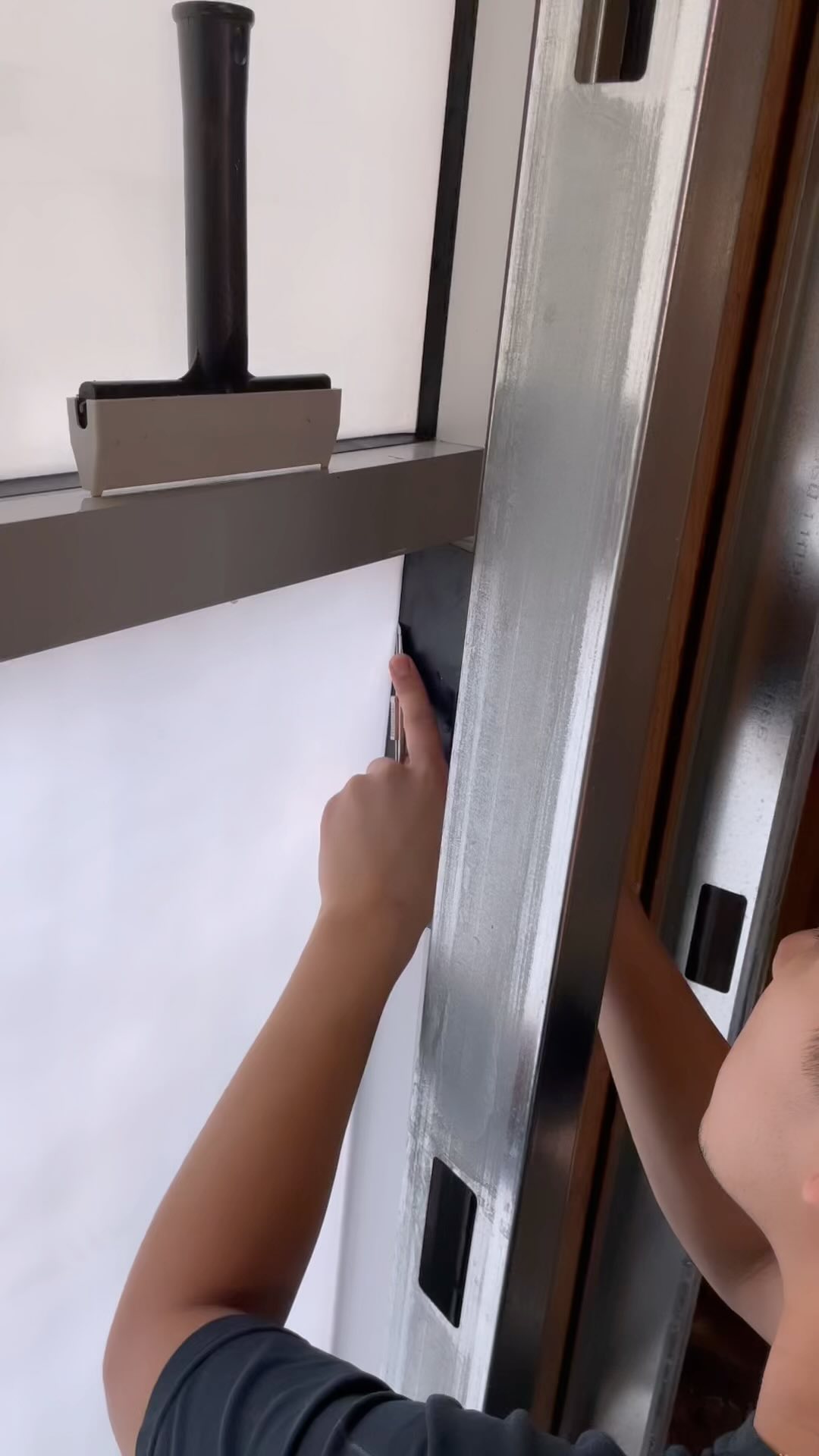 Installer trimming the edge of frosted film on a glass door
